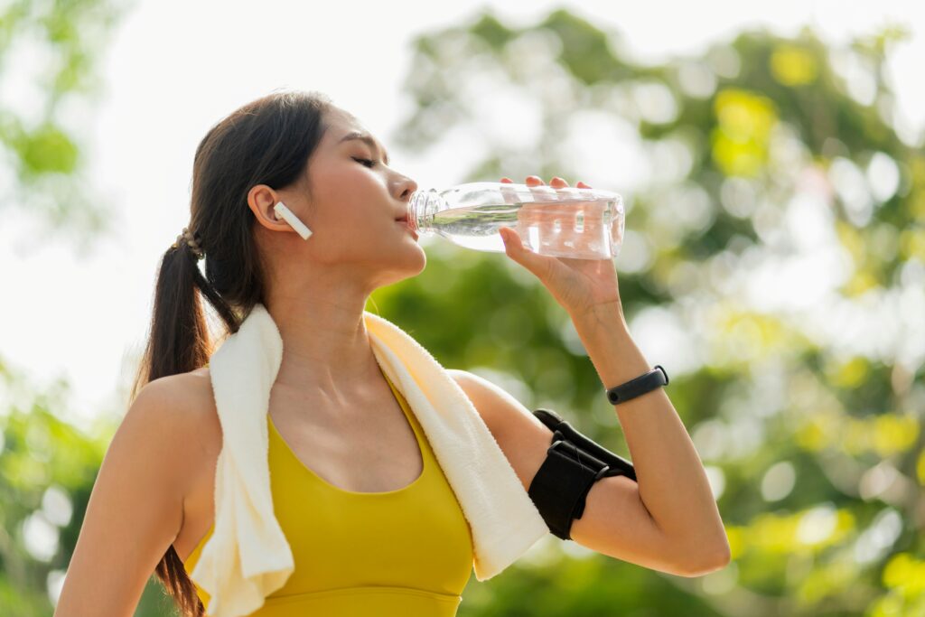a woman drinking from a water bottle