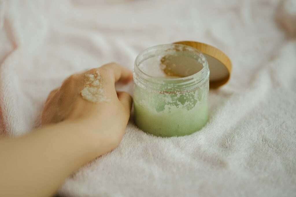a woman applying body scrub that's green